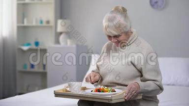 微笑的老妇人在养老院吃晚餐，老年人的社会保障